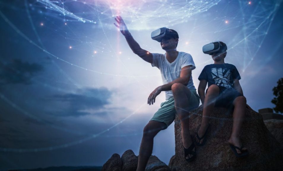 Father and son using Virtual Reality glasses sitting outside
